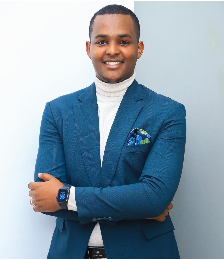 Canary Mugume smiling in greenish blue suit