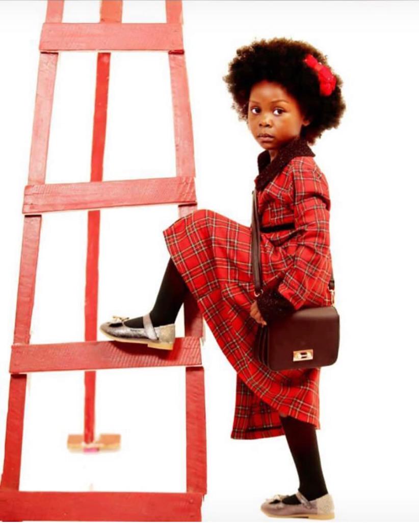 Baby Adeuiz poses in red outfit with leg raised