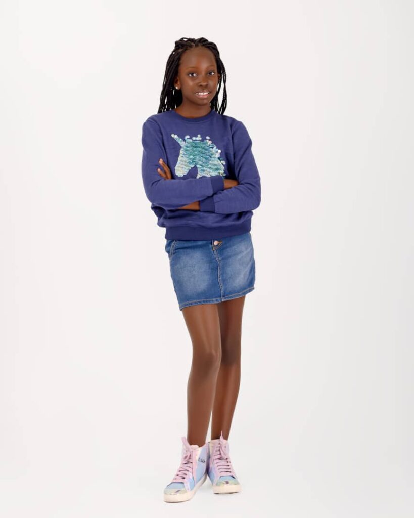 Mugasa Myra | Unravelling The Dazzling Ugandan Kid Model 11 Mugasa Myra standing in sweater and mini jean skirt