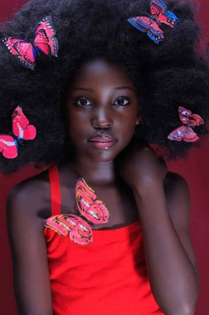 Mugasa Myra | Unravelling The Dazzling Ugandan Kid Model 4 Mugasa Myra with read butterflies in her spreadout fluffy african hair