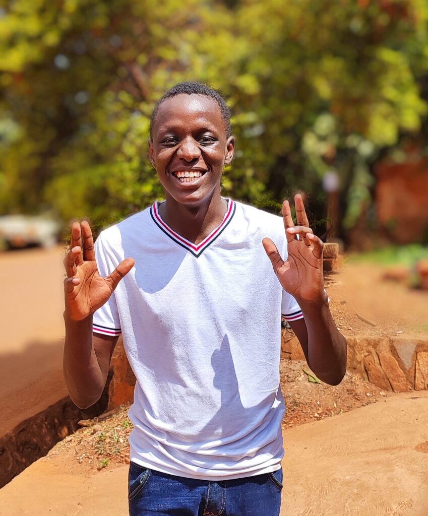 Why John Kenny Adeya Began Kampala Edge Times In 2018 1 John kenny Adeya smiling in a white T-Shirt
