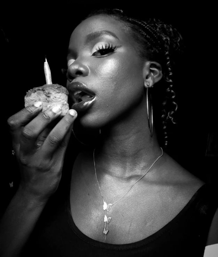 Beautiful black girl eating a cake with a candle with fire